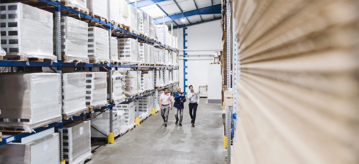 Three people walking in warehouse
