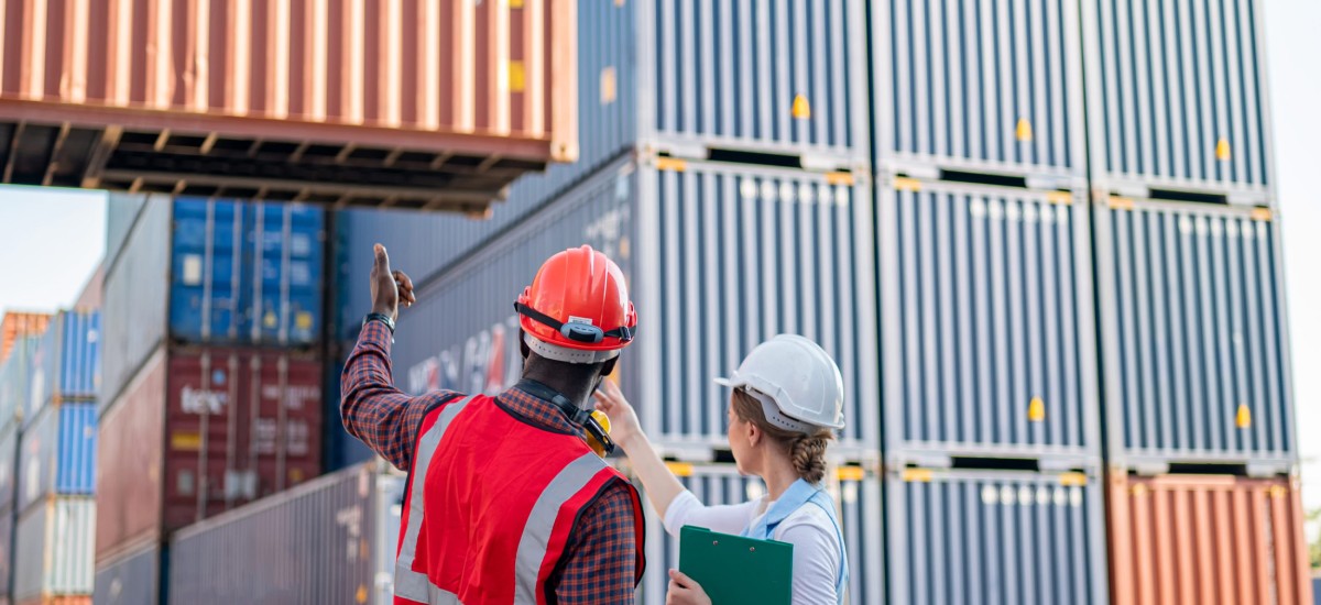 Two people inspecting shipping containers