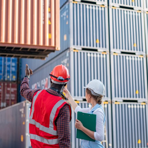Two people inspecting shipping containers