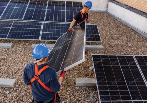 Men lifting solar panels on a roof